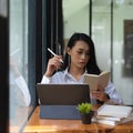 Female office worker working with schedule book and digital tablet Royalty Free Stock Photo