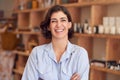 Portrait Of Female Owner Of Gift Store Standing In Front Of Shelves With Cosmetics And Candles Royalty Free Stock Photo