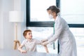 Portrait of female pediatrician wearing white uniform applying plaster on shoulder of child boy after vaccination Royalty Free Stock Photo