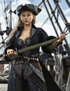 Portrait of a female pirate mercenary standing on the deck of her ship armed and ready for battle. Royalty Free Stock Photo