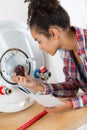 Portrait female plumber working on central heating boiler Royalty Free Stock Photo