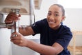 Portrait Of Female Plumber Working To Fix Leaking Sink In Home Bathroom Royalty Free Stock Photo