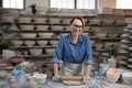 Portrait of female potter flattening the clay with rolling pin