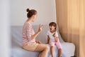 Portrait of female professional speech therapist working with little girl, having language lesson for improving speaking, people