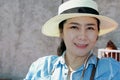 Portrait of female protrait in white hat and looking at camera.