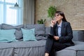Portrait of female psychologist with clipboard sitting on couch in office Royalty Free Stock Photo