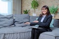 Portrait of female psychologist with clipboard sitting on couch in office Royalty Free Stock Photo