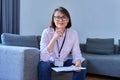 Portrait of female psychologist sitting on sofa in office