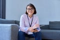 Portrait of female psychologist sitting on sofa in office Royalty Free Stock Photo