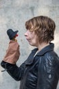 Portrait of a female puppeteer with strange facial expression playing with a Kasper doll with a red nose, copy space Royalty Free Stock Photo