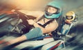 Female racer in helmet driving kart on track