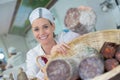 Portrait female seller offering wursts in local butchery