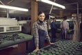 Portrait of a female shoe factory worker standing at a desk with patterns for future shoes. Royalty Free Stock Photo