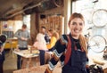 Portrait Of Female Small Business Owner In Workshop Assembling Hand Built Bamboo Bicycles