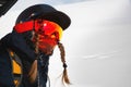 Portrait of a female snowboarder in a mask climbing to the top on a cable car at a ski resort against a snow-covered Royalty Free Stock Photo