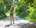 Portrait of female in sportswear stretching her arms up after exercise in nature Royalty Free Stock Photo