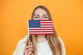 Portrait of a female student covering her face with a small american flag Royalty Free Stock Photo