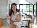 Female student holding notebook and pencil while standing in cafe Royalty Free Stock Photo