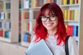 Portrait of female college student in glasses with laptop backpack, looking at camera Royalty Free Stock Photo