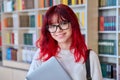 Portrait of female college student in glasses with laptop backpack, looking at camera Royalty Free Stock Photo