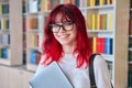 Portrait of female college student in glasses with laptop backpack, looking at camera Royalty Free Stock Photo