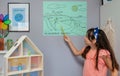 Student showing types of renewable energies in poster at ecology classroom Royalty Free Stock Photo