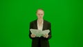 Portrait of female in suit on chroma key green screen. Blonde business woman in formal outfit holding paper.