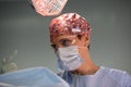 Portrait of a female surgeon in a modern operating room, a professional surgeon in a mask with glasses and gloves.