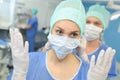 Portrait female surgeon showing surgical gloves in operation room Royalty Free Stock Photo