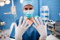 Portrait of female surgeon showing surgical gloves in operation room Royalty Free Stock Photo