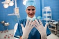 Portrait of female surgeon showing surgical gloves in operation room Royalty Free Stock Photo