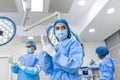 Portrait of female surgeon in surgical uniform in operation theater looking away. Doctor in scrubs and medical mask in modern Royalty Free Stock Photo