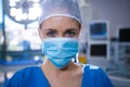 Portrait of female surgeon wearing surgical mask in operation theater Royalty Free Stock Photo