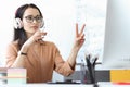 Portrait of female teacher in headphones conducting online lesson remotely