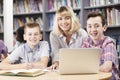 Portrait Of Female Teacher Helping Two Male High School Students Royalty Free Stock Photo