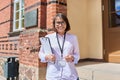 Portrait of female teacher looking at camera outdoor on steps of school building Royalty Free Stock Photo