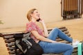 Female traveler sitting with bags and talking on mobile phone Royalty Free Stock Photo
