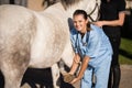 Portrait of female vet examining horse hoof Royalty Free Stock Photo