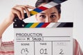 Portrait Of Female Videographer Holding Clapper Board On Video Film Production In White Studio Royalty Free Stock Photo