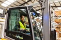 Female warehouse worker driving forklift. Warehouse worker preparing products for shipmennt, delivery, checking stock in Royalty Free Stock Photo