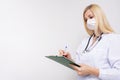 Portrait of a female woman doctor with prescription board in hands and face medical surgical mask on the face