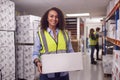 Portrait Of Female Worker Inside Busy Warehouse Carrying Box Royalty Free Stock Photo