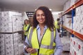 Portrait Of Female Worker Inside Busy Warehouse Checking Stock On Shelves Using Digital Tablet Royalty Free Stock Photo