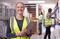 Portrait Of Female Worker Inside Busy Warehouse Checking Stock On Shelves Using Digital Tablet Royalty Free Stock Photo