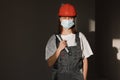 Portrait female worker is wear protection mask face, safety helmet and suit and with big screw key, wrench in hands. For working Royalty Free Stock Photo