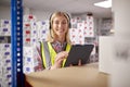 Portrait Of Female Worker Wearing Headset In Logistics Distribution Warehouse Using Digital Tablet Royalty Free Stock Photo