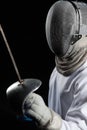 Portrait of fencer woman wearing white fencing costume practicing with the sword. Isolated on black background.