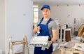 Portrait of a fifteen year old worker in uniform with a roller and a pallet Royalty Free Stock Photo