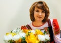 Portrait of fifty well-groomed woman in Russian folk costume with a bouquet of flowers