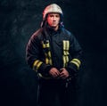 Portrait of firefighter dressed in uniform and safety helmet looking sideways with a confident look Royalty Free Stock Photo